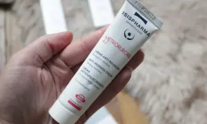 Crème anti-rougeurs pour la rosacée, contenant de l'acide azélaïque. Le tube Metroruboril A.Z d'Isispharma est tenu dans une main.