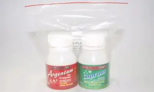 Dwie butelki płynów do czyszczenia: Argentum do srebra i Cuprum do metali kolorowych, w plastikowym opakowaniu.