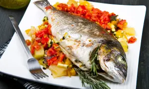 Dorada a la espalda, horneada con verduras y hierbas frescas, lista para disfrutar.
