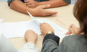 Biegły psychiatra analizuje dokumenty, omawiając przebieg badania psychiatrycznego.