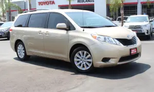 Złoty minivan Toyota Sienna stoi przed salonem Toyota Redlands.