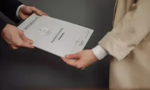 Wręczenie dokumentu "Akt poświadczenia dziedziczenia" w kancelarii notarialnej.