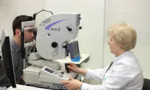 Badanie okulistyczne z użyciem angiografii fluoresceinowej. Lekarz bada pacjenta, monitorując potencjalne skutki uboczne.