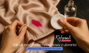 Jak zmyć lakier hybrydowy z ubrania? Na jedwabnej tkaninie plama z różowego lakieru, obok wacik i buteleczka z płynem.