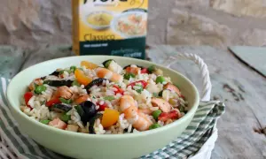 Un'appetitosa insalata di riso con pesce, gamberetti, verdure e olive, pronta per essere gustata.