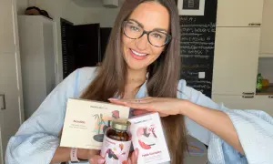 Kobieta z okularami prezentuje suplementy Health Labs Care, które pomagają w walce z niską ferrytyną i poprawiają kondycję skóry.