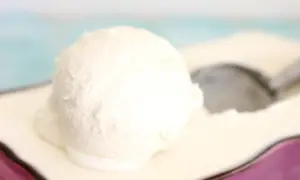 Una bola cremosa de helado de nata Thermomix sobre un plato, lista para ser disfrutada.