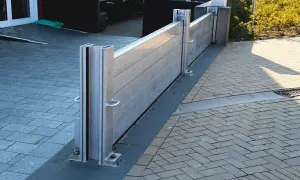 Moderne mobile Hochwasserschutzwand schützt das Haus vor Überschwemmungen. Sie ist aus Aluminium gefertigt und an den Pfosten befestigt.