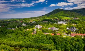 Ustroń i okolice co zwiedzić? Widok z lotu ptaka na zielone wzgórza, charakterystyczne budynki i lasy.