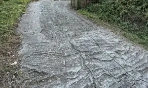 Stromy podjazd z popękanego betonu, z widocznymi śladami po koleinach. Zastanawiasz się, czym wyłożyć stromy podjazd?