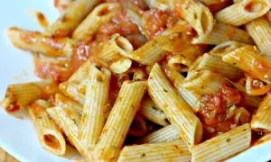 Pyszny makaron penne z aromatycznym sosem pomidorowym, posypany ziołami. Idealny na szybki obiad.