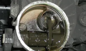 Mécanisme de transmission avec un embrayage bloqué en bas, baignant dans une huile sombre.