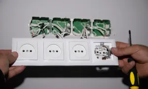 Montaż gniazdek elektrycznych. Widać przewody wychodzące z puszki instalacyjnej i przygotowywane do podłączenia. To pierwszy krok, by dowiedzieć się, jak podłączyć licznik jednofazowy orno.
