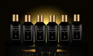 Sześć czarnych flakonów perfum Birkholz z złotymi nakrętkami. Jeden z nich to "Dark Amber", o głębokim, **dark amber** kolorze.