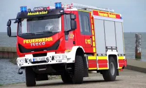 Czerwony wóz strażacki Iveco z napisem "Feuerwehr Hooksiel" i numerem 112. To jeden z rodzajów wozów strażackich, gotowy do akcji.
