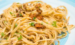 Linguine condite con un saporito sugo ai ricci di mare, guarnite con prezzemolo fresco.