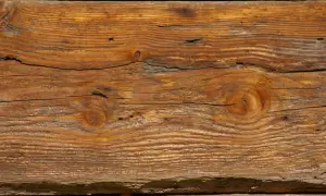 Słoje drewna tworzą piękny, naturalny wzór. Widoczne są sęki i pęknięcia, nadające mu charakterystyczny efekt starego drewna.