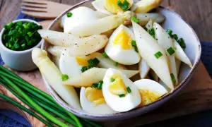 Klassisches Spargelsalat Rezept: Zarter weißer Spargel mit hartgekochten Eiern und Schnittlauch, garniert mit Pfeffer.