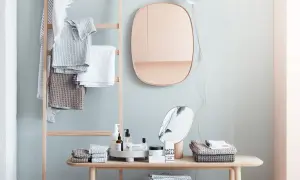 Sanfte Wandfarbe in Hellblau harmoniert perfekt mit dem hellen Buchenholz-Regal und den grauen Handtüchern.