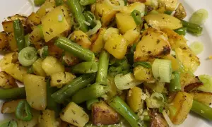 Herzhafte Kartoffel-Bohnen-Pfanne mit Frühlingszwiebeln, goldbraun gebraten und mit Kräutern verfeinert. Ein Genuss!