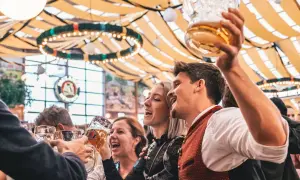 Allegra compagnia brinda con boccali di birra, festeggiando l'Oktoberfest. Litri di birra scorrono in un'atmosfera di gioia.