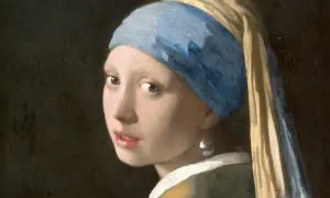 Dziewczyna z perłą, w błękitnym turbanie i złotej chuście, spogląda tajemniczo. Jej spojrzenie przyciąga uwagę.