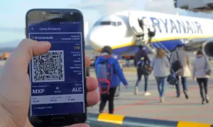 Karta pokładowa to bilet Wizzair na telefonie, z kodem QR, na tle samolotu Ryanair i pasażerów idących na pokład.
