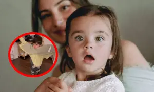 Dziecko z pomocą mamy uczy się, jak założyć kurtkę. Mama z uśmiechem obserwuje malucha.
