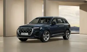 Eleganckie, ciemnogranatowe nowe Audi Q7 prezentuje się na tle nowoczesnej architektury i malowniczego krajobrazu.