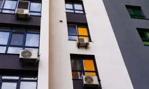 Klimatyzacja w bloku, zamontowana na ścianie z oknami, zapewnia komfortowe warunki.