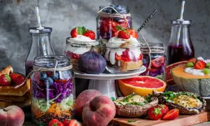 Färgglada burkar med frukt och grönsaker, perfekta för ett somrigt brunch recept. Jordgubbar, blåbär, kål och quinoa i lager.