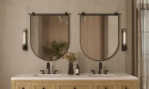 A modern bathroom vanity with two sinks, featuring oval mirrors with a subtle mirror thickness.