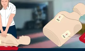 Ćwiczenie RKO z AED. Na manekinie widoczne elektrody AED, sugerujące brak akcji serca (asystolia ekg).