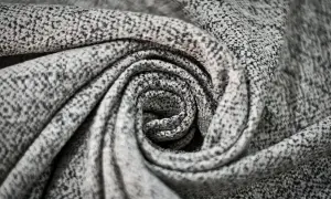 Graues, gemustertes Polyester-Material, kunstvoll zu einer Spirale gedreht.