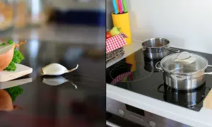 Cebula i czosnek na płycie ceramicznej czy indukcyjnej, obok garnków i koszyka z warzywami.