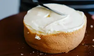 Bizcocho esponjoso cubierto con glaseado blanco cremoso, listo para decorar. Una deliciosa receta bizcocho.