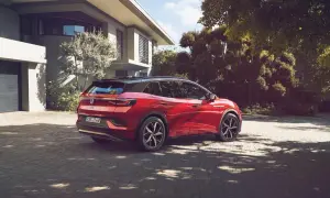 Röd elbil parkerad på uppfart framför modernt hus. En dag för att fundera på hur många elbilar som finns i Sverige.