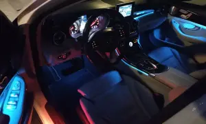 Wnętrze Mercedesa C W205 z niebieskim i czerwonym oświetleniem ambientowym.