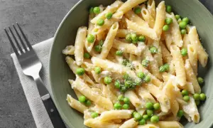 Penne z kremowym sosem i zielonym groszkiem, posypane parmezanem. Idealne danie, gdy masz ochotę na pyszny makaron z groszkiem.