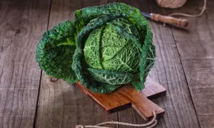 Ein frischer Wirsingkopf liegt auf einem Holzbrett, bereit für leckere Wirsing Rezepte.