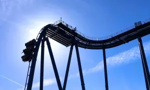 Wagonik z pasażerami na szczycie najwyższego rollercoastera na świecie, tuż przed zjazdem.