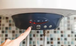 Palec naciska przycisk na bojlerze elektrycznym 60l, pokazując ustawienia temperatury. Zastanawiasz się, ile prądu zużywa bojler elektryczny 60l?