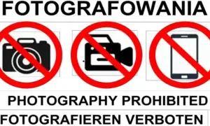 Zakaz fotografowania obiektów wojskowych. Na znaku widać przekreślony aparat, kamerę i telefon.