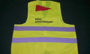 Kamizelka odblaskowa w kolorze limonkowym z napisem "NEW AMSTERDAM" i czerwonym logo. To przykład znakowania odzieży.