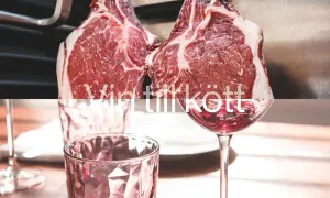 Två råa ryggbiffar hänger redo för grillen, med ett glas rött vin som väntar. Perfekt vin till ryggbiff.