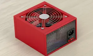 Czerwony zasilacz komputerowy z wentylatorem i siatką. Posiada przełącznik 220V i gniazdo zasilania. PFC zapewnia stabilne działanie.