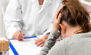 Lekarz notuje, pacjentka zmartwiona, zastanawia się, ile trwa psychoza.