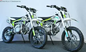 Dwa biało-zielone motocykle typu pit bike stojące obok siebie.