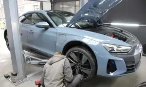 Mechanik wymienia opony w szarym Audi. Zastanawiasz się, ile trwa wymiana opon? Zazwyczaj to szybka usługa.