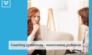 Kobieta z rudymi włosami słucha uważnie podczas sesji. Coaching systemowy pomaga odkryć nowe perspektywy.